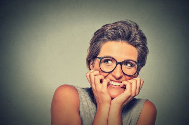 nervous stressed anxious young woman with glasses girl biting fingernails