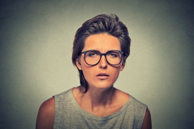 Displeased unsure arguable suspicious thinking young lady in glasses clipart