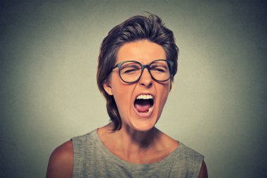 Angry young woman with glasses screaming clipart