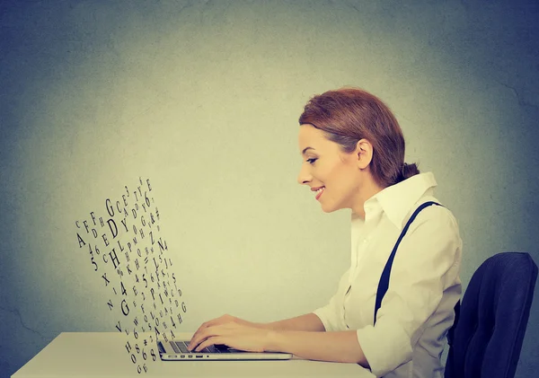 Woman typing on laptop computer with screen made of alphabet letters flying up — Stok fotoğraf