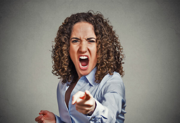 angry young woman pointing finger at camera screaming