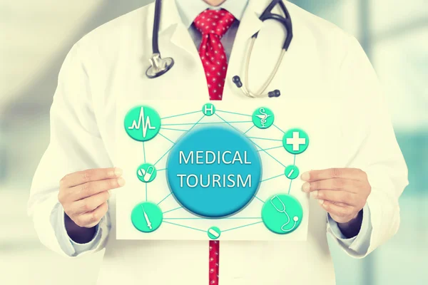 Doctor hands holding card sign with medical tourism message — 图库照片
