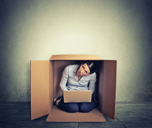 Businesswoman hiding in the box working on computer - Stock Image ...