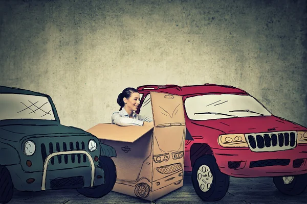 Young woman parking her compact car in between large SUV gas guzzlers — 스톡 사진