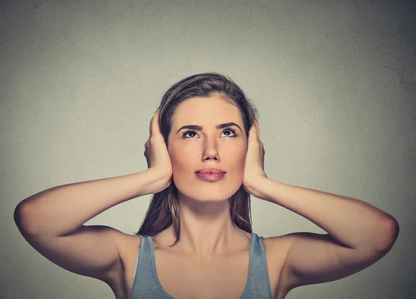 Mujer molesta, infeliz, estresada cubriéndose las orejas, mirando hacia arriba — Foto de Stock