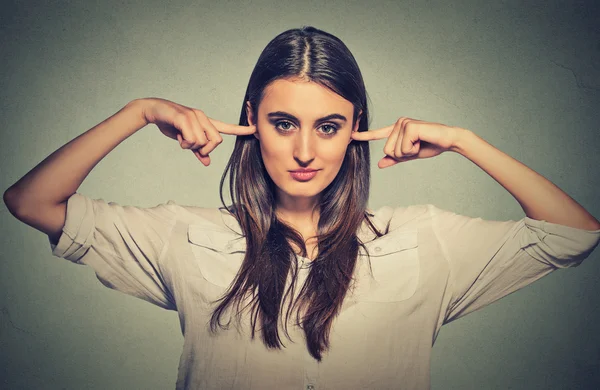 Woman plugging ears with fingers doesn't want to listen — Stock Photo, Image