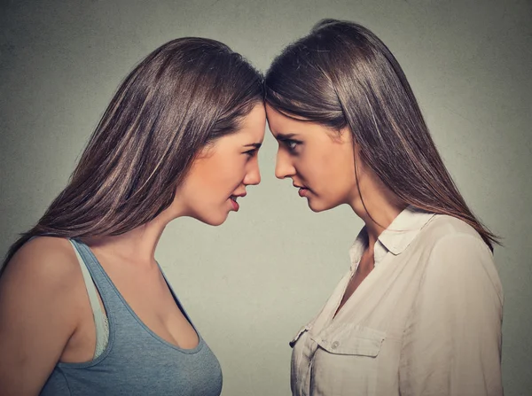Side profile unhappy young female friends looking at each other — Stock Photo, Image