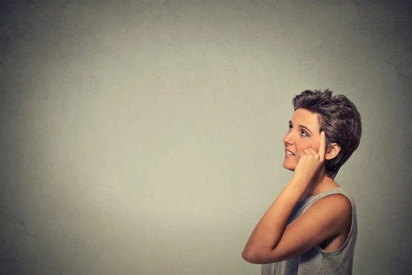 Happy woman thinking looking up finger on head — 图库照片