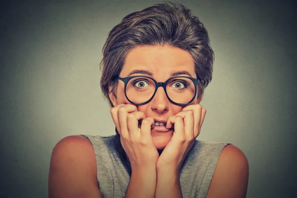 Nervous stressed anxious young woman with glasses girl biting fingernails — Zdjęcie stockowe