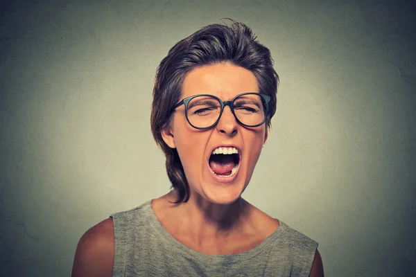 Angry young woman with glasses screaming — Stockfoto