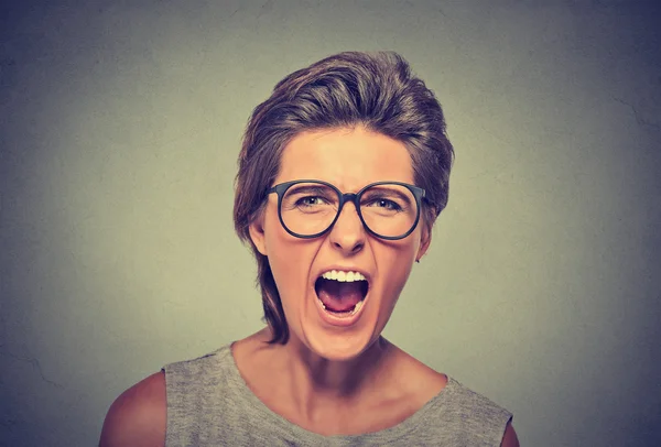 Angry young woman with glasses screaming — Stockfoto