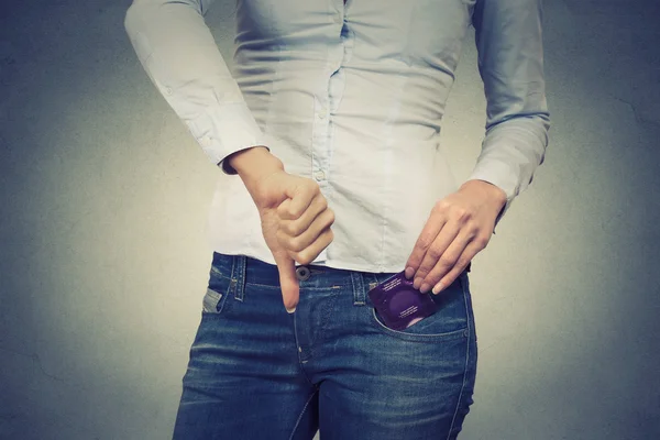 Mujer con condón en el bolsillo dando pulgares hacia abajo —  Fotos de Stock