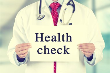 Doctor hands holding white card sign with health check text message