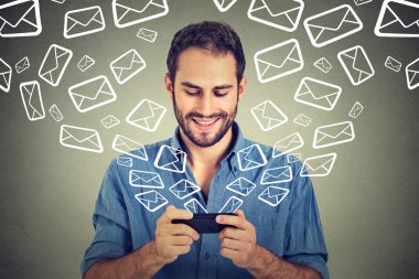Portrait young happy man busy sending messages emails from smart phone clipart