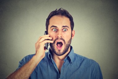 Shocked man talking on mobile phone