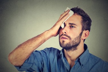 Tired man stressed sweating having fever headache