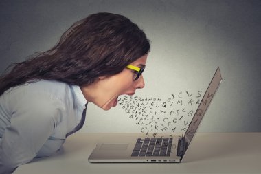 Angry furious businesswoman working on computer, screaming