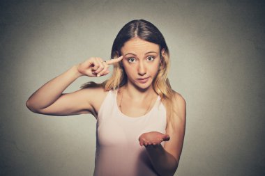 angry mad woman gesturing with her finger against temple asking are you crazy?