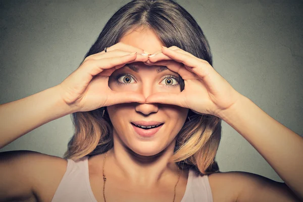 Donna curiosa stordita, sbirciando tra le dita come un binocolo — Foto Stock