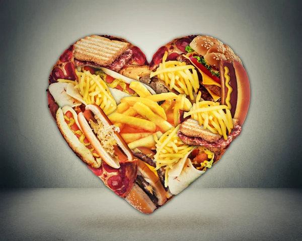 Coração e má dieta conceito de risco de acidente vascular cerebral. Coração em forma de fast junk comida gordurosa — Fotografia de Stock