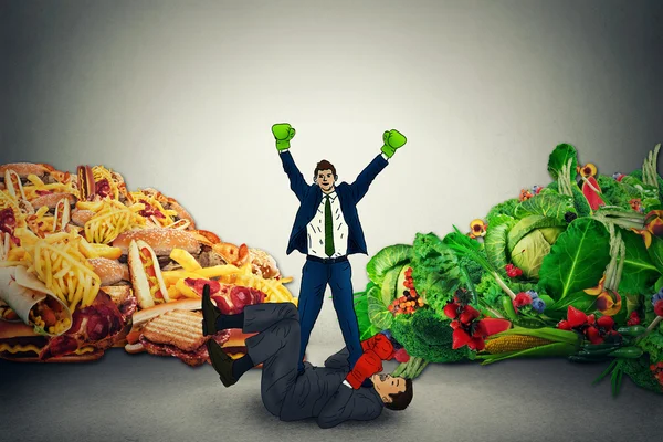 Vegetarian food representative winner in fight with unhealthy junk fatty food — Stock fotografie