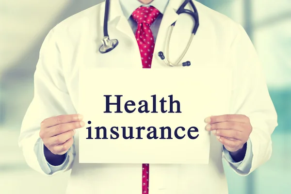 Doctor hands holding white card sign with health insurance text message — Stockfoto