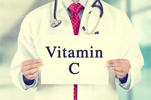 Ärztin hält weißes Kartenschild mit Vitamin-C-SMS in Händen — Stockfoto