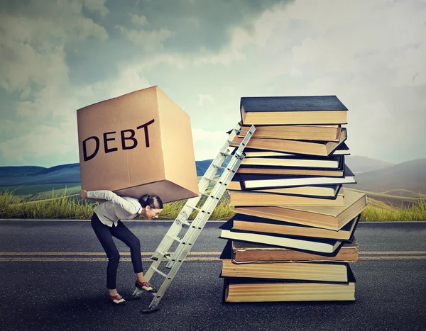 Concetto di debito studentesco. Donna con un pesante debito di scatola che lo porta su scala di istruzione — Foto Stock
