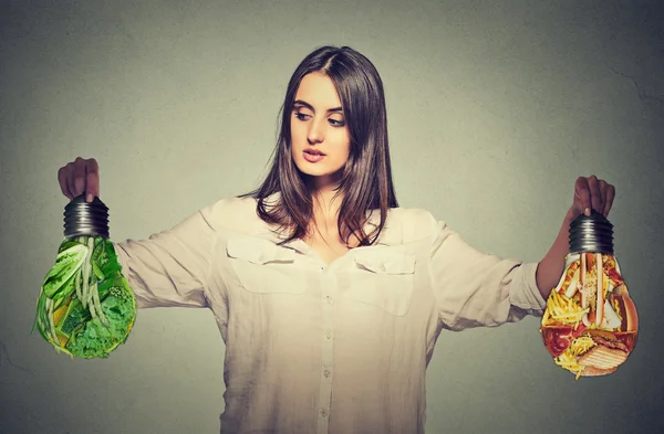 Woman thinking making diet choices junk food or green vegetables — Stock Photo, Image