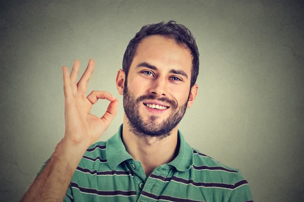 Mann gestikuliert ok Zeichen isoliert auf grauem Wand Hintergrund — Stockfoto