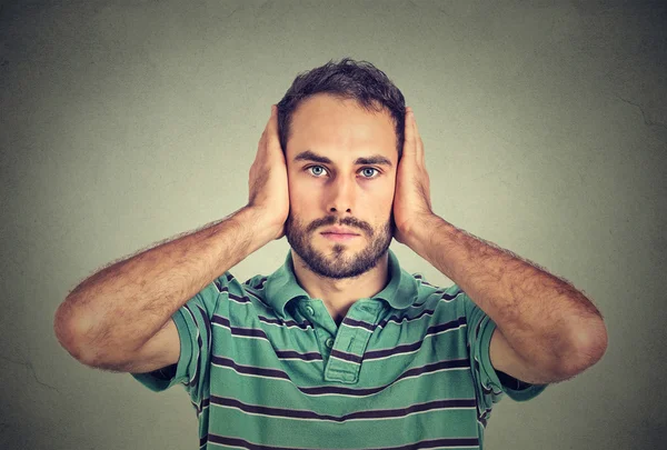 Jeune homme couvrant ses oreilles avec des mains — Photo