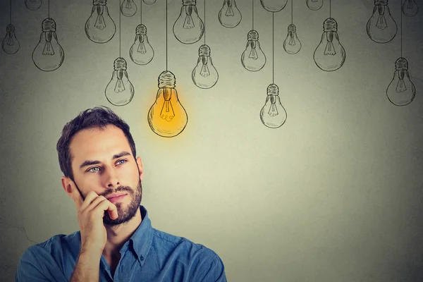 Man looking up with idea light bulb above head — Stockfoto