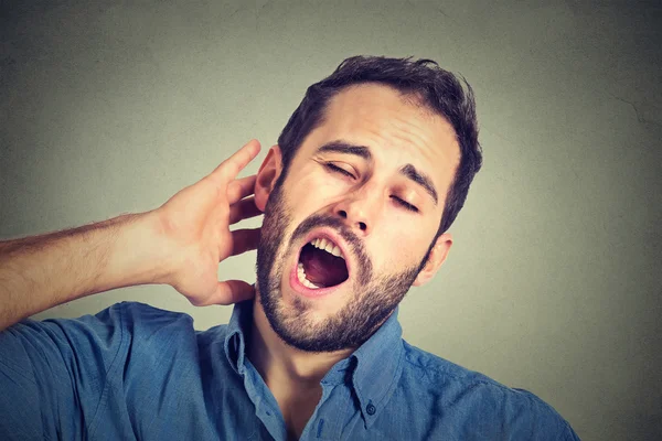 Young sleepy man yawning stretching arms back — Stock Photo, Image