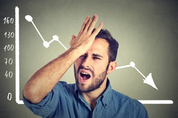 Frustrated stressed young man desperate with financial market chart graphic going down — Stock Photo, Image