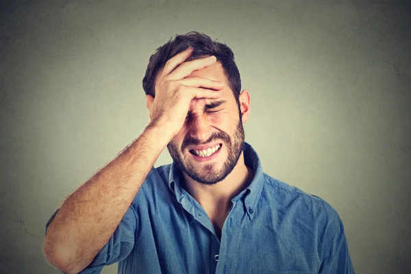 Retrato estressado homem sofrendo de dor de cabeça isolado no fundo da parede cinza — Fotografia de Stock