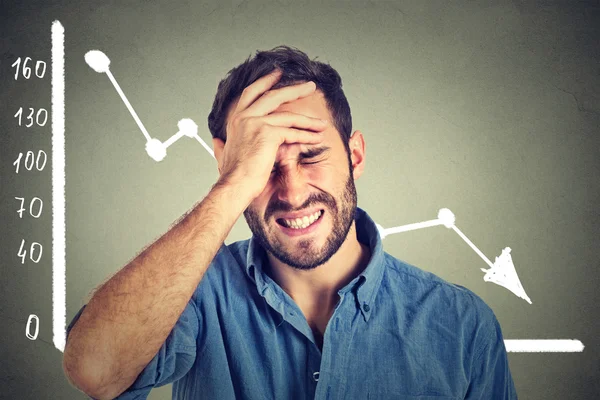 Frustrated stressed young man desperate with financial market chart graphic going down — Stock Photo, Image