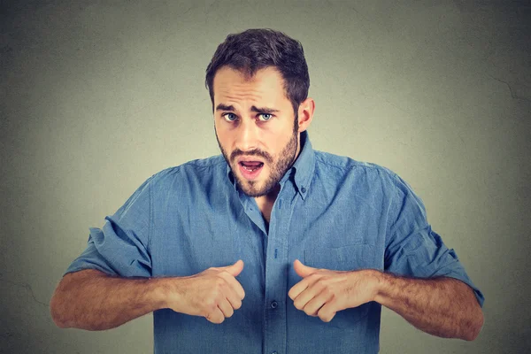 Angry, mad, unhappy guy pointing at himself as if to say, you mean me? — Stock Photo, Image