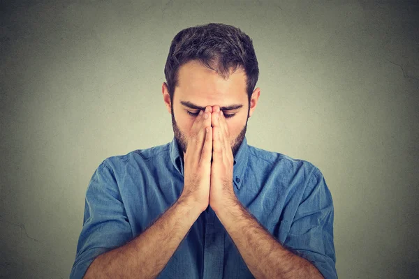 Portrait of young desperate sad man isolated on gray wall background — Stockfoto