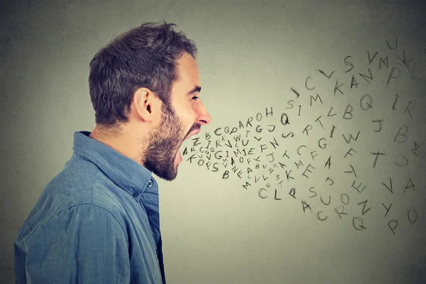 Θυμωμένος άνθρωπος ουρλιάζοντας με γράμματα του αλφαβήτου που φέρουν έξω από το στόμα ορθάνοιχτο — Φωτογραφία Αρχείου