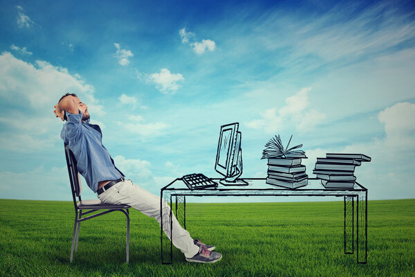 man relaxing at his desk outdoors