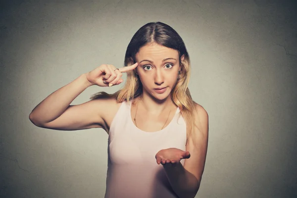 Angry mad woman gesturing with her finger against temple asking are you crazy? — Stok fotoğraf