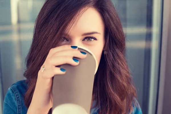 Femme souriante buvant du café à l'extérieur tenant tasse en papier — Photo