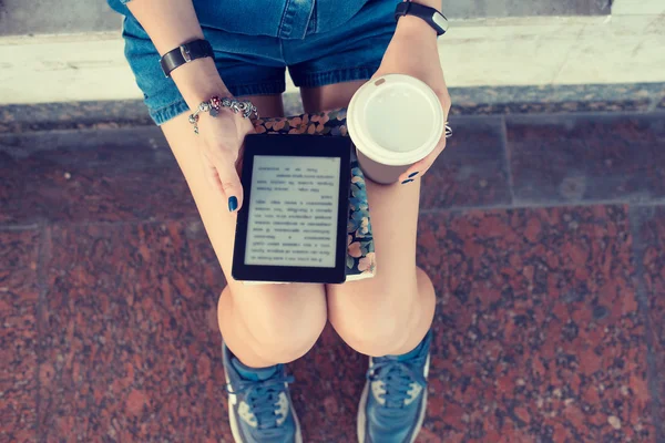 Donna che utilizza tablet digitale seduto sulla panchina, navigando Internet bere caffè — Foto Stock