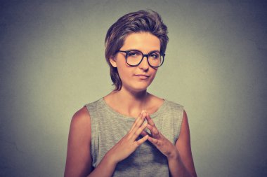 sneaky, sly, scheming young woman in glasses trying to plot something