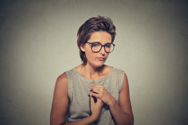 Lack of confidence. Shy young woman in glasses feels awkward