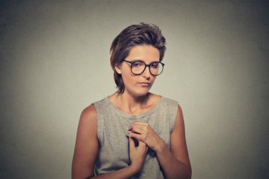 Lack of confidence. Shy young woman in glasses feels awkward clipart