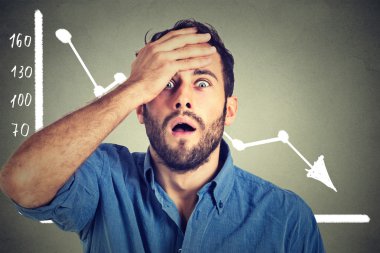 stressed shocked business man with financial market chart graphic going down