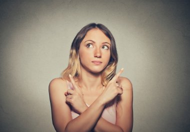 Confused thinking woman isolated on gray wall background