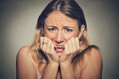 nervous stressed young woman biting fingernails looking anxiously craving