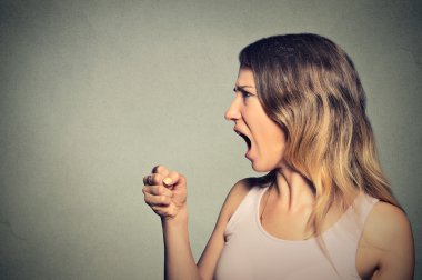 Angry woman screaming with fist up in air
